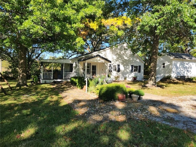 back of house featuring a lawn and covered porch