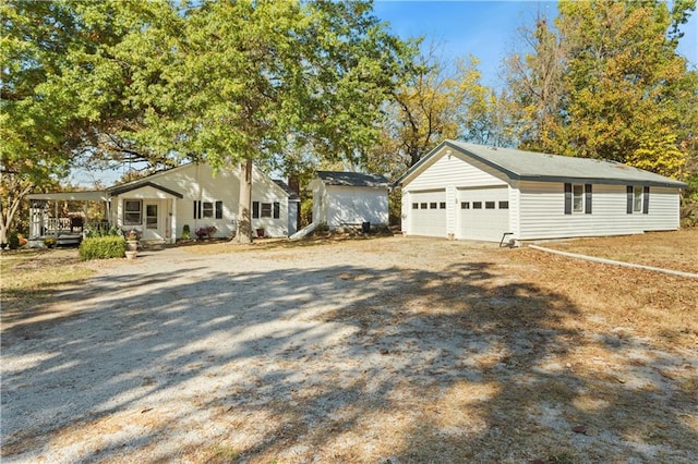 view of front facade featuring an outbuilding, covered porch, and a garage