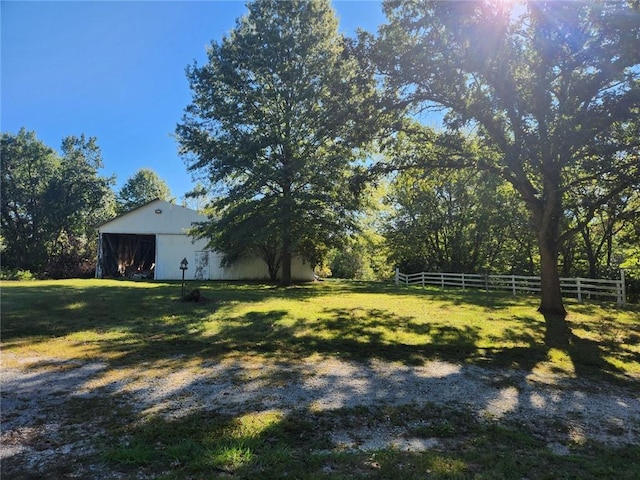 view of yard with fence, an outbuilding, and an outdoor structure