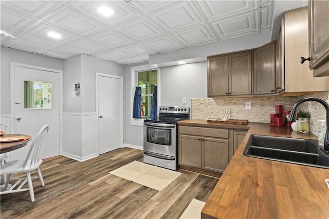 kitchen featuring tasteful backsplash, sink, electric range, butcher block countertops, and dark hardwood / wood-style floors