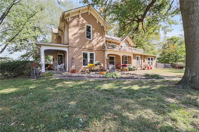 view of front of property with a front lawn, covered porch, and a balcony