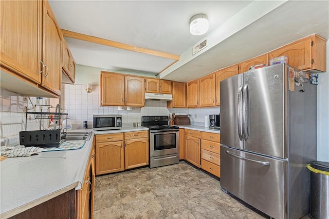 kitchen featuring under cabinet range hood, backsplash, appliances with stainless steel finishes, and light countertops