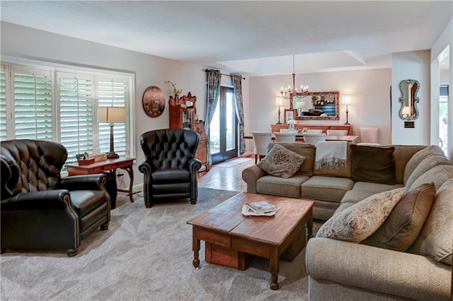 living room featuring light carpet, a chandelier, and plenty of natural light