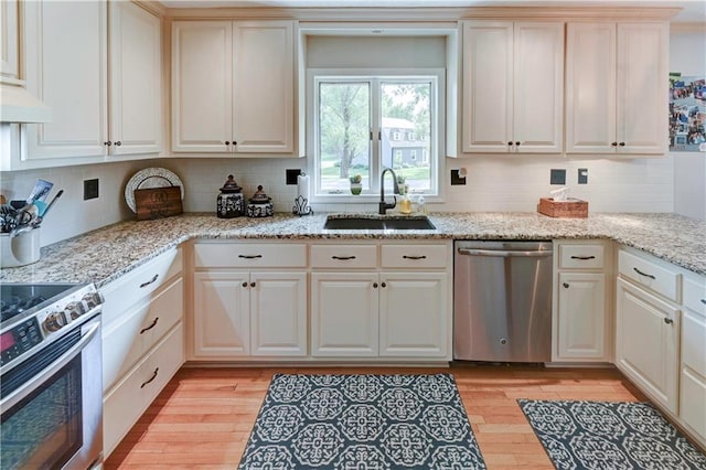 kitchen featuring light wood-type flooring, decorative backsplash, sink, and stainless steel appliances