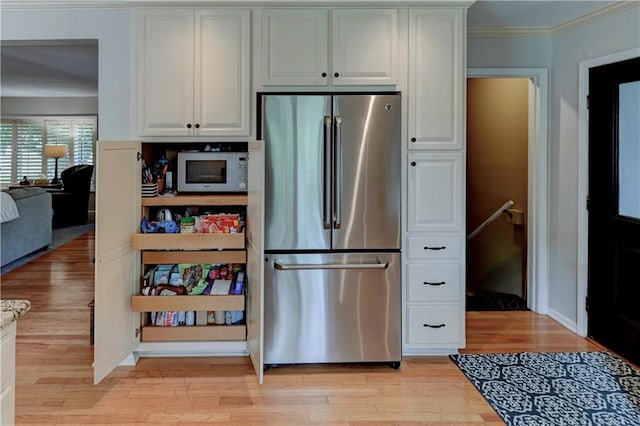 kitchen featuring light hardwood / wood-style flooring, white cabinetry, crown molding, and stainless steel fridge