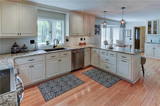 kitchen with pendant lighting, stainless steel appliances, plenty of natural light, and kitchen peninsula