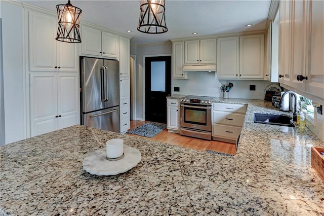 kitchen with ornamental molding, sink, stainless steel appliances, and decorative light fixtures