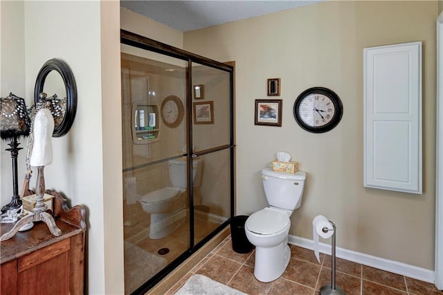 bathroom with tile patterned flooring, toilet, and an enclosed shower