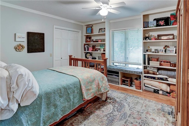 bedroom with ceiling fan, hardwood / wood-style flooring, a closet, and ornamental molding