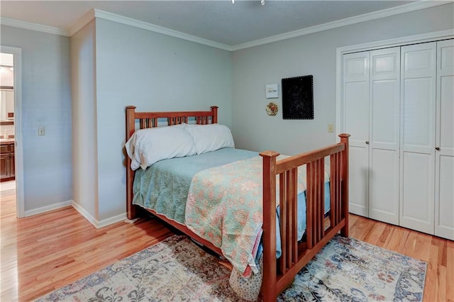 bedroom featuring crown molding, light hardwood / wood-style floors, and a closet