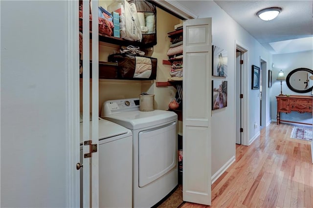 laundry room featuring light hardwood / wood-style flooring and washing machine and dryer