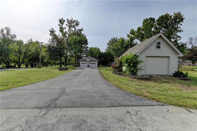 view of front of home featuring a front yard, an outdoor structure, and a garage