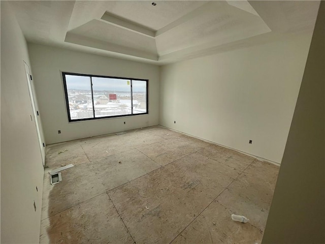 empty room featuring a raised ceiling