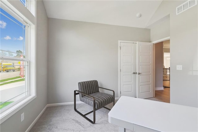 bedroom featuring light carpet, lofted ceiling, and multiple windows