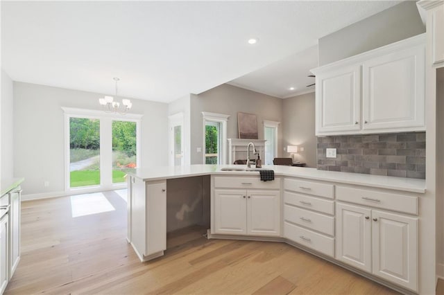 kitchen with light hardwood / wood-style flooring, white cabinetry, and pendant lighting