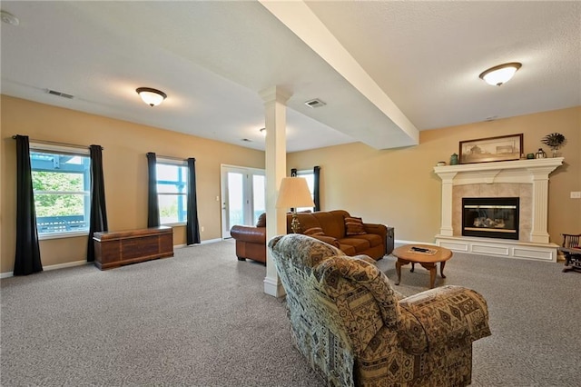 carpeted living room featuring a tiled fireplace