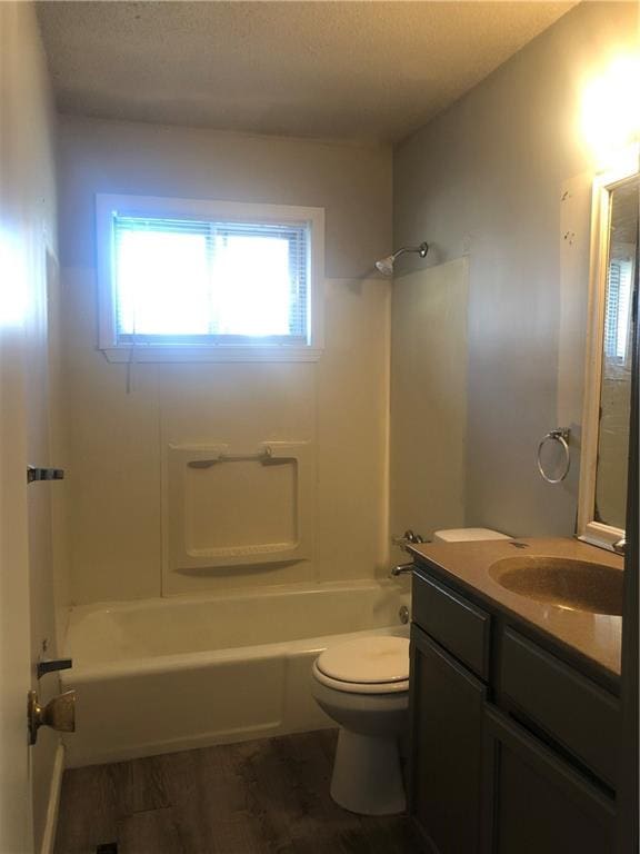 full bathroom with vanity, toilet, a textured ceiling, and bathing tub / shower combination