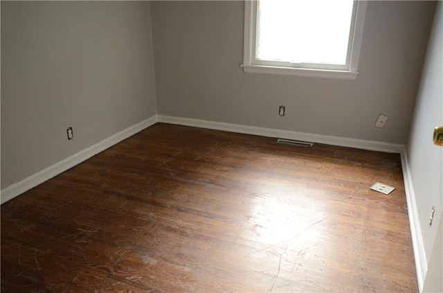 unfurnished room with dark hardwood / wood-style flooring