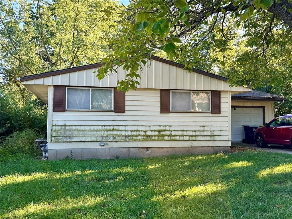 view of home's exterior with a garage and a yard