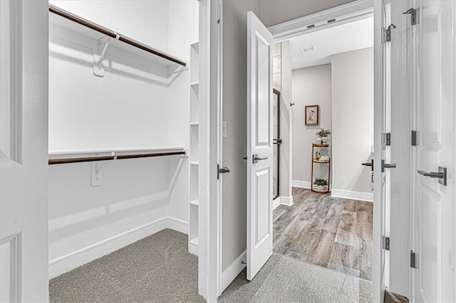 walk in closet featuring light hardwood / wood-style flooring