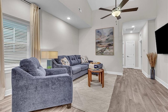 living room featuring light hardwood / wood-style floors, high vaulted ceiling, and ceiling fan