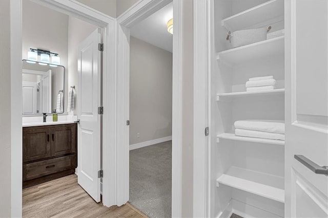 5830 Hunter Ct, Raytown, MO 64133 - bathroom featuring wood finished floors, vanity, and baseboards