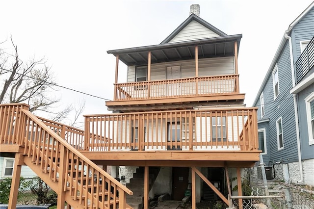 rear view of property featuring cooling unit and a wooden deck