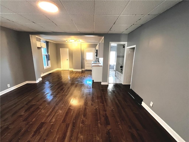 interior space featuring dark hardwood / wood-style flooring, a wealth of natural light, a paneled ceiling, and sink