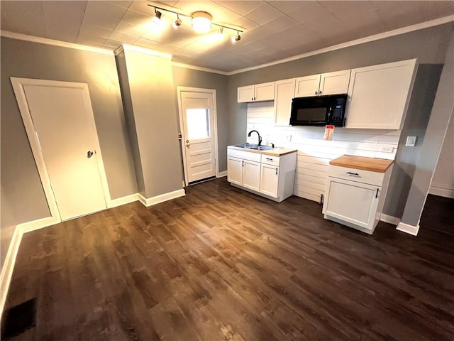 kitchen featuring butcher block countertops, dark hardwood / wood-style flooring, white cabinets, and sink