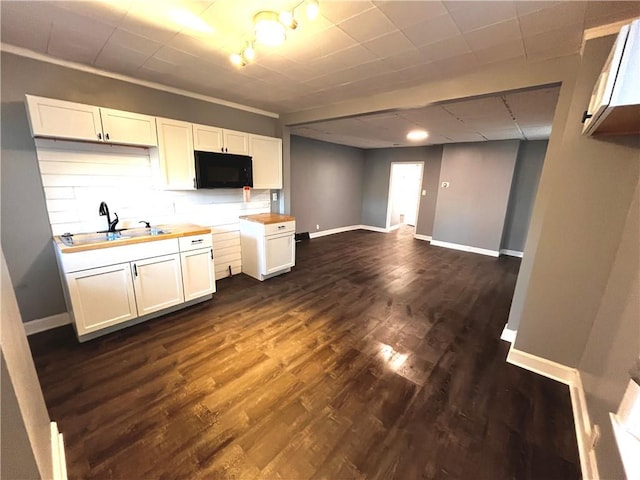 kitchen with butcher block counters, sink, white cabinets, and dark hardwood / wood-style flooring