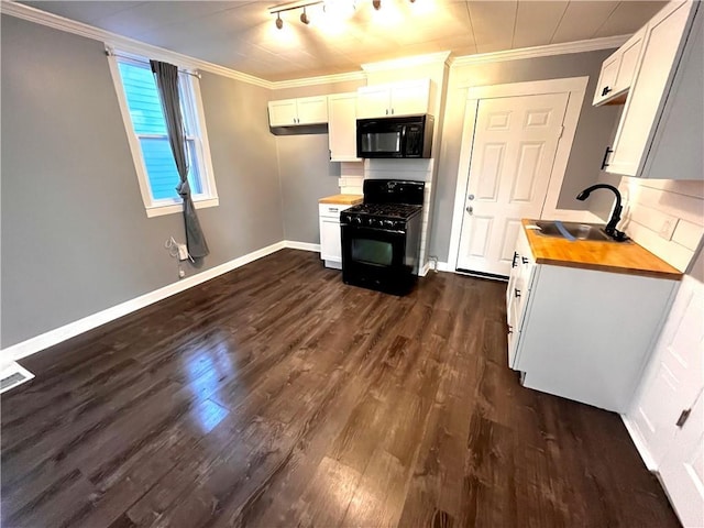 kitchen featuring sink, butcher block countertops, white cabinetry, and black appliances