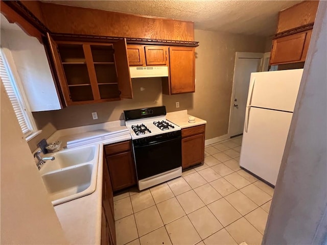 kitchen with white appliances, sink, light tile patterned floors, a textured ceiling, and extractor fan