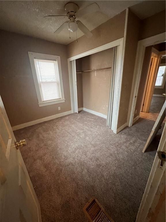 unfurnished bedroom with ceiling fan, a closet, and carpet