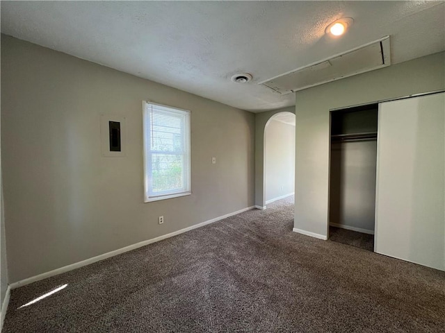 unfurnished bedroom featuring a textured ceiling, carpet flooring, and a closet