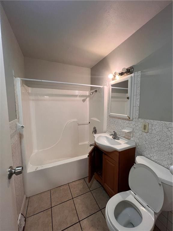 full bathroom featuring vanity, toilet, shower / bathing tub combination, tile walls, and tile patterned flooring