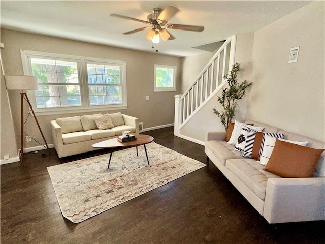 living room featuring dark wood-type flooring and ceiling fan