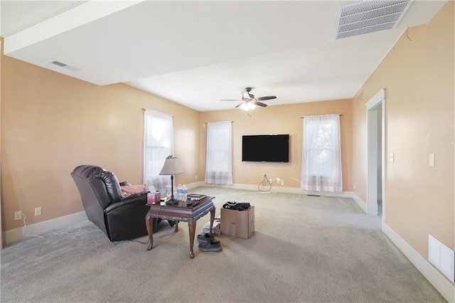 carpeted living room with a healthy amount of sunlight and ceiling fan