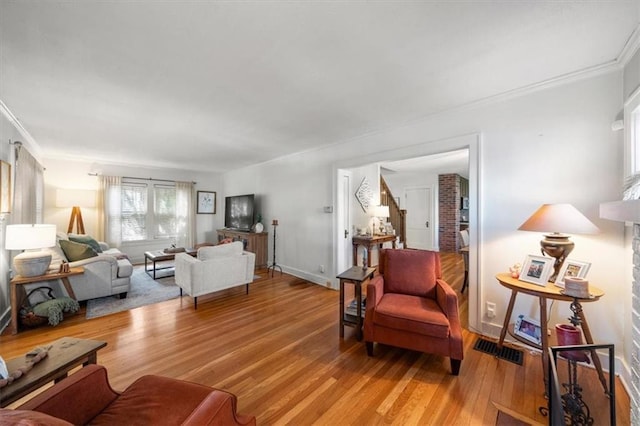 living room with light hardwood / wood-style flooring and crown molding