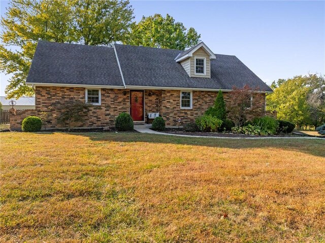 3438 N 123rd St, Kansas City, KS 66109 - new england style home with a front yard, fence, brick siding, and roof with shingles