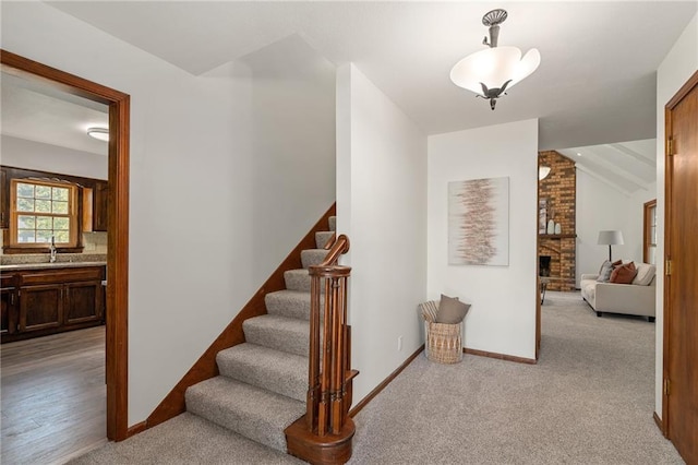 3438 N 123rd St, Kansas City, KS 66109 - stairway with lofted ceiling, a fireplace, baseboards, and carpet floors