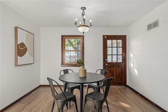 3438 N 123rd St, Kansas City, KS 66109 - dining space featuring visible vents, light wood finished floors, baseboards, and a notable chandelier