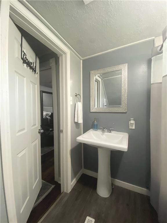 bathroom featuring hardwood / wood-style flooring and a textured ceiling