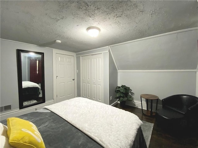 bedroom featuring lofted ceiling, a textured ceiling, and dark hardwood / wood-style floors