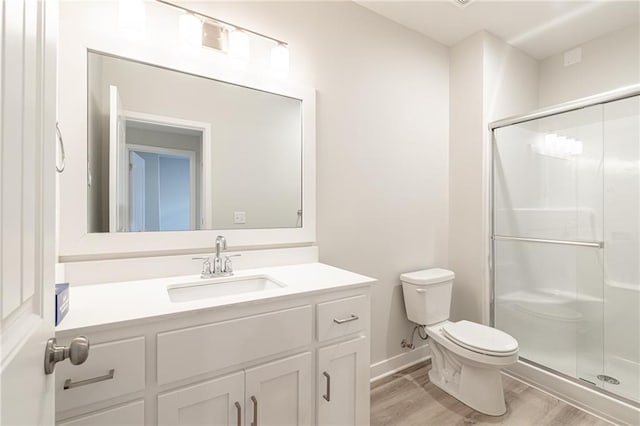 bathroom featuring walk in shower, vanity, toilet, and hardwood / wood-style flooring