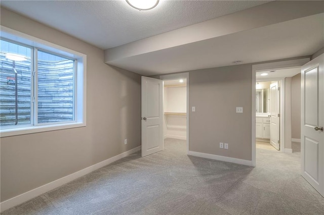 basement with light colored carpet and a textured ceiling