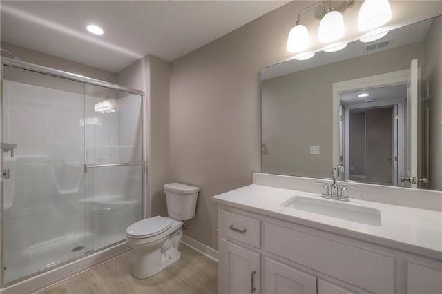 bathroom with a shower with door, vanity, hardwood / wood-style flooring, and toilet