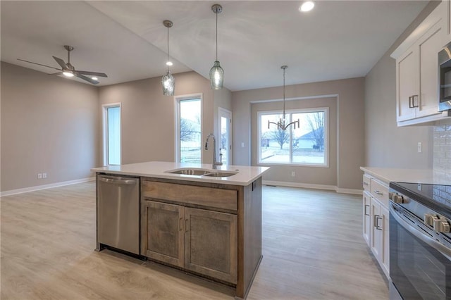 kitchen with pendant lighting, white cabinetry, an island with sink, sink, and stainless steel appliances