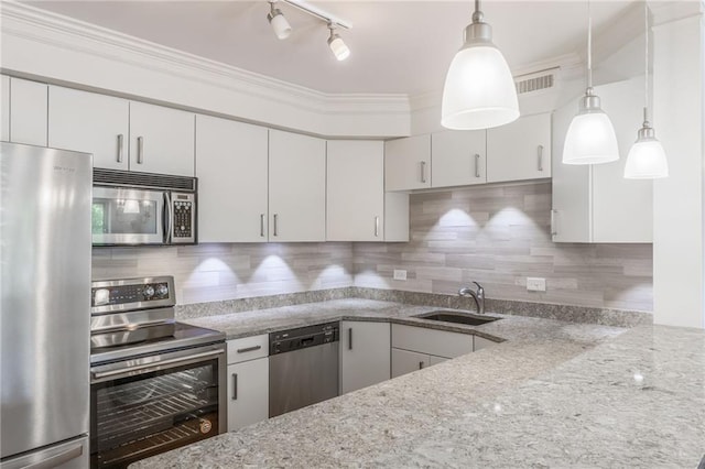 kitchen featuring decorative light fixtures, stainless steel appliances, sink, and tasteful backsplash