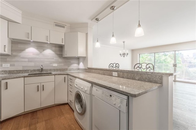 kitchen with pendant lighting, dishwasher, hardwood / wood-style flooring, sink, and white cabinetry