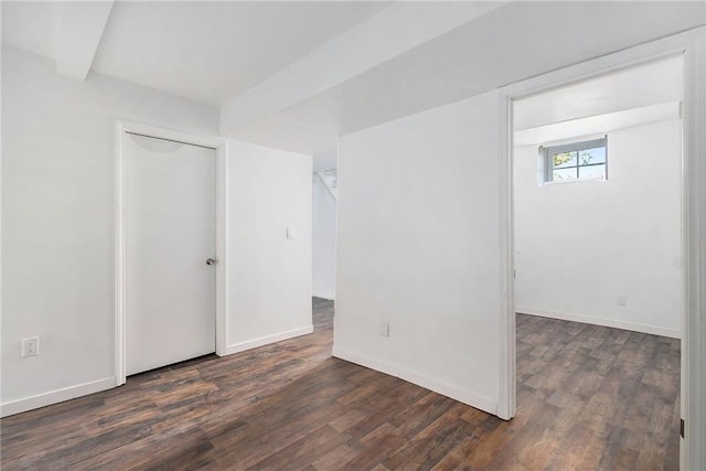 unfurnished room featuring dark wood-style flooring and baseboards